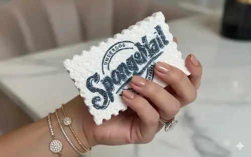 Hand holding a spongemail eco kitchen sponges product with 'SpongeMail'